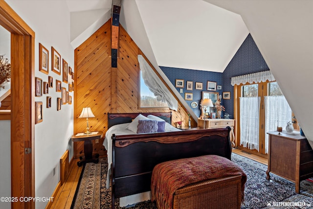 bedroom with baseboards, high vaulted ceiling, and wood finished floors