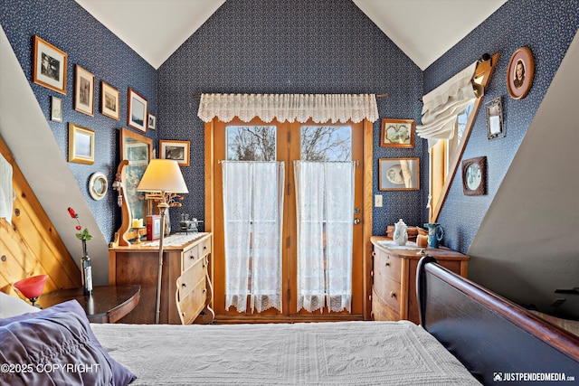 bedroom with wallpapered walls and vaulted ceiling