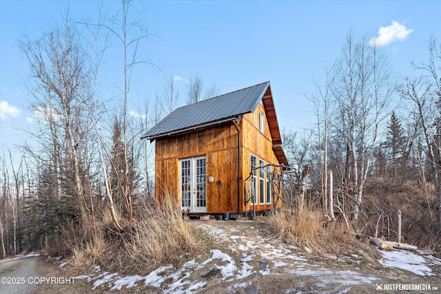 snow covered property featuring metal roof