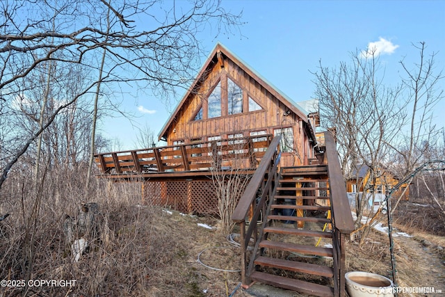 back of property with stairs and a deck