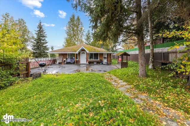 back of property with an outbuilding and a patio area