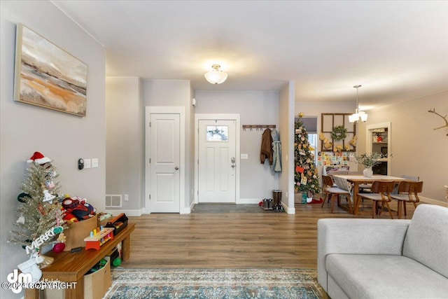 foyer entrance with an inviting chandelier and hardwood / wood-style floors