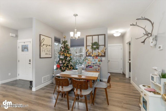 dining area featuring an inviting chandelier and hardwood / wood-style flooring