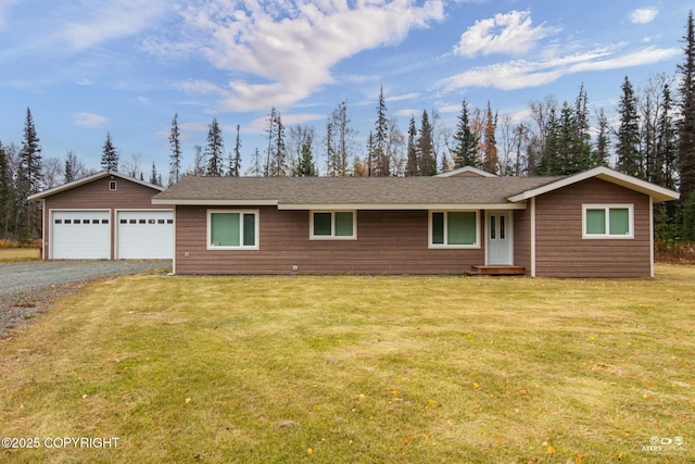 single story home featuring a garage, an outbuilding, and a front yard