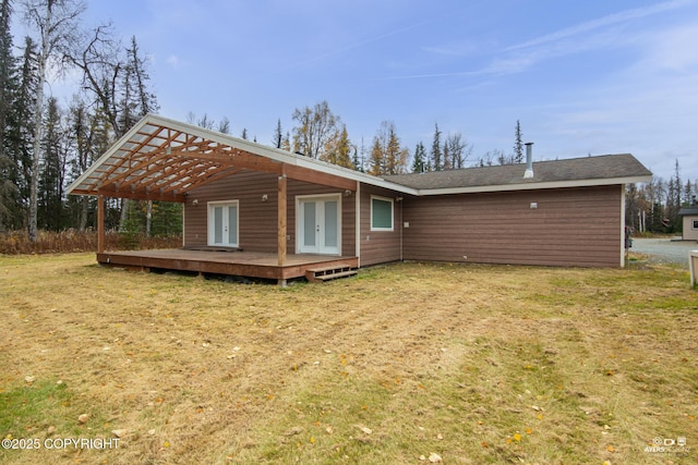 rear view of house featuring a wooden deck, a yard, and french doors