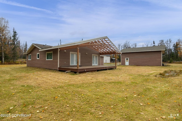 back of property with a pergola, a wooden deck, and a yard