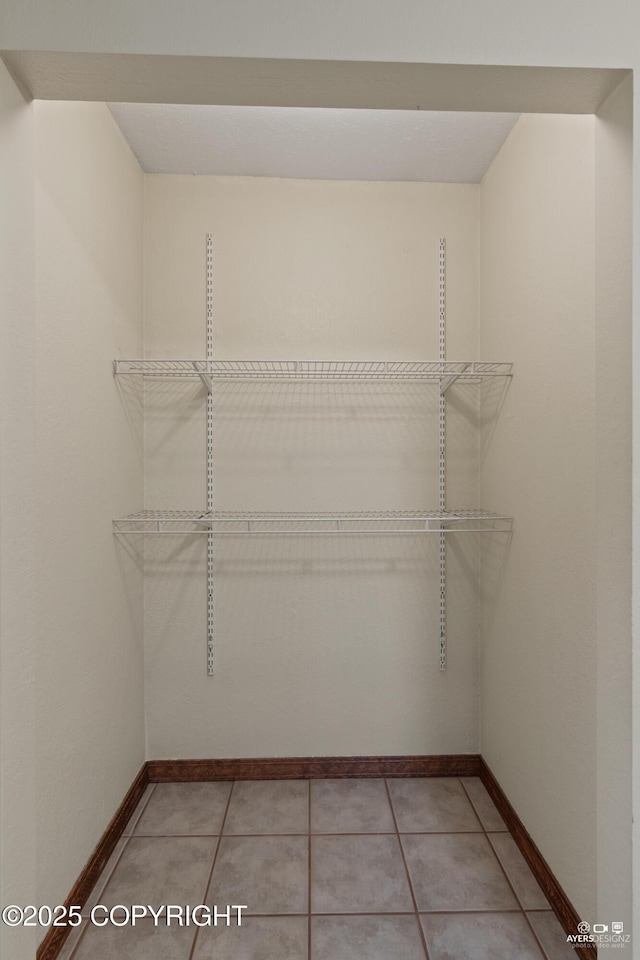 walk in closet featuring light tile patterned flooring