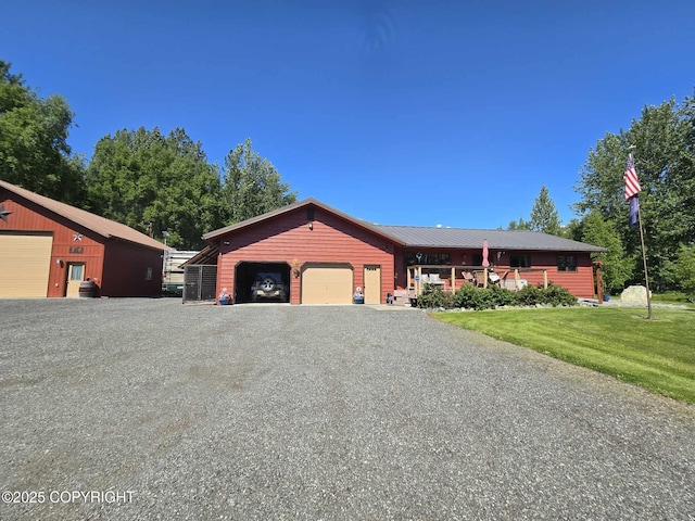 view of front facade with gravel driveway, a front lawn, and an attached garage