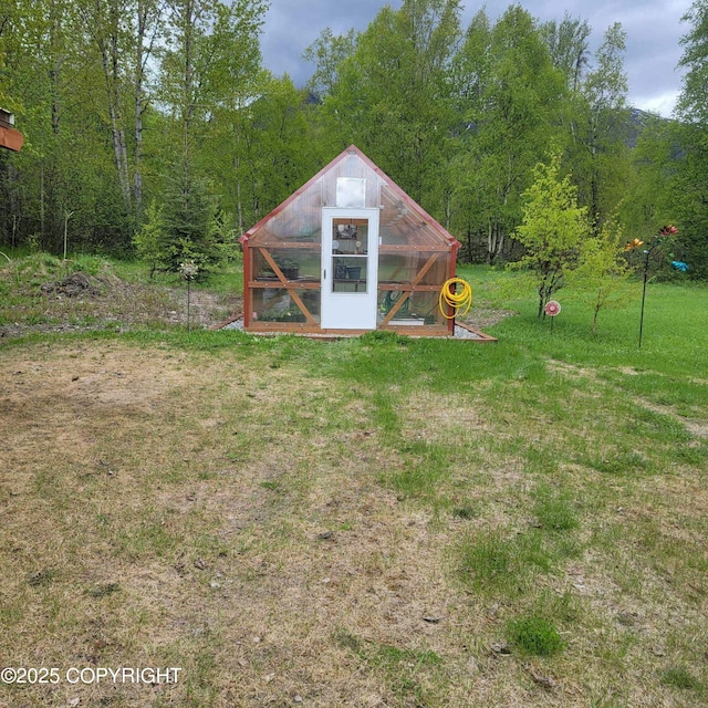 view of greenhouse with a lawn