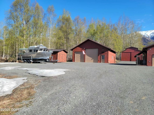 view of front of property featuring a detached garage, a storage shed, and an outdoor structure