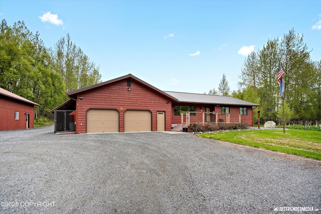 5853 E Edgerton Parks Rd, Palmer, AK 99645 - rustic home featuring an attached garage, gravel driveway, covered porch, and a metal roof