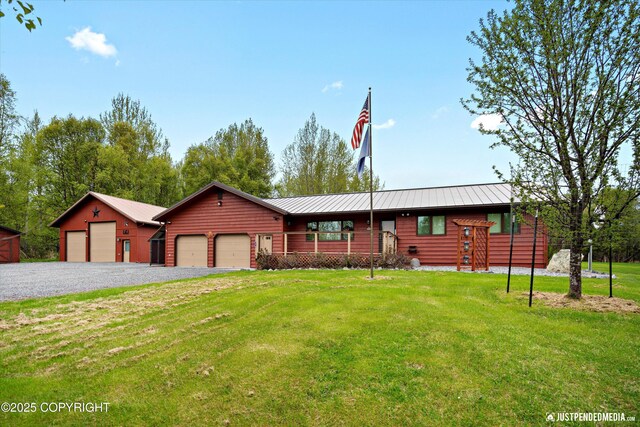5853 E Edgerton Parks Rd, Palmer, AK 99645 - log home featuring a front lawn, a metal roof, a standing seam roof, an attached garage, and gravel driveway