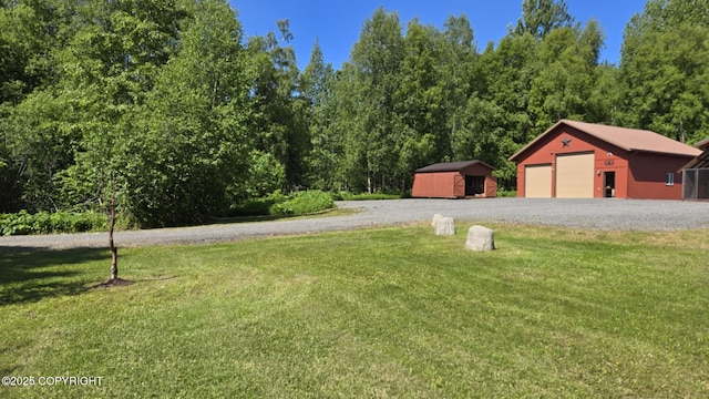 5853 E Edgerton Parks Rd, Palmer, AK 99645 - view of green lawn with an outbuilding and a garage