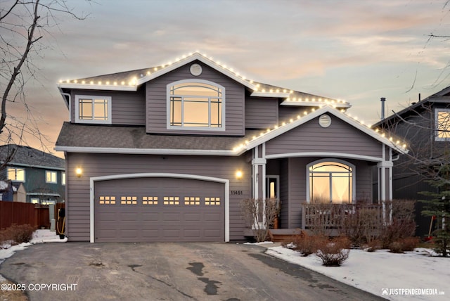 traditional-style home featuring a garage and driveway