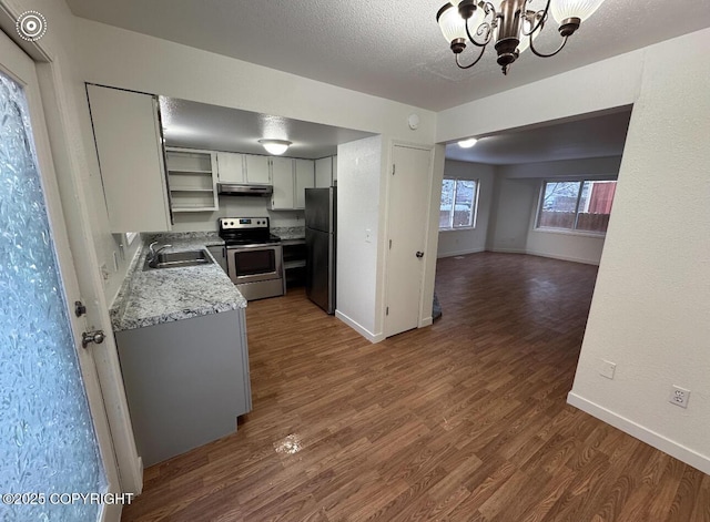 kitchen with a chandelier, sink, a textured ceiling, stainless steel appliances, and dark wood-type flooring