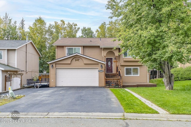 split foyer home featuring a garage, aphalt driveway, and a front lawn