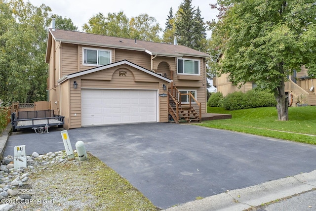 view of front of property featuring an attached garage, driveway, and a front lawn