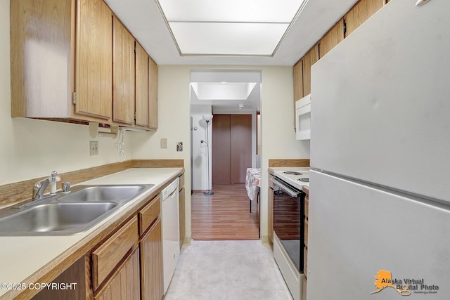 kitchen featuring white appliances, light tile patterned floors, and sink