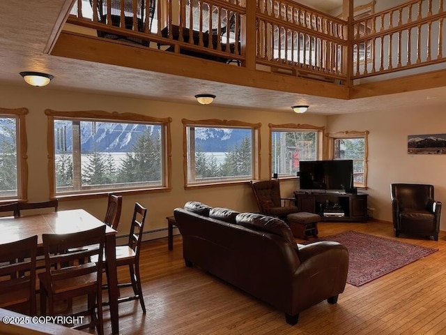 living area featuring wood-type flooring, a high ceiling, and a wealth of natural light