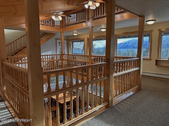 interior space with carpet floors, a baseboard heating unit, and a wealth of natural light