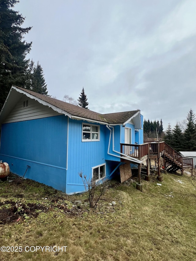 back of house with a deck, a yard, and stairs