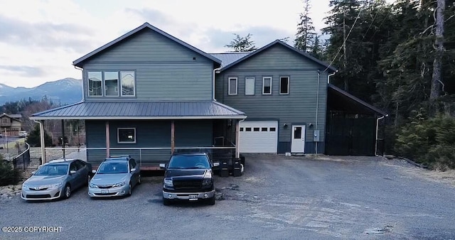 view of front facade with a garage, a mountain view, and covered porch