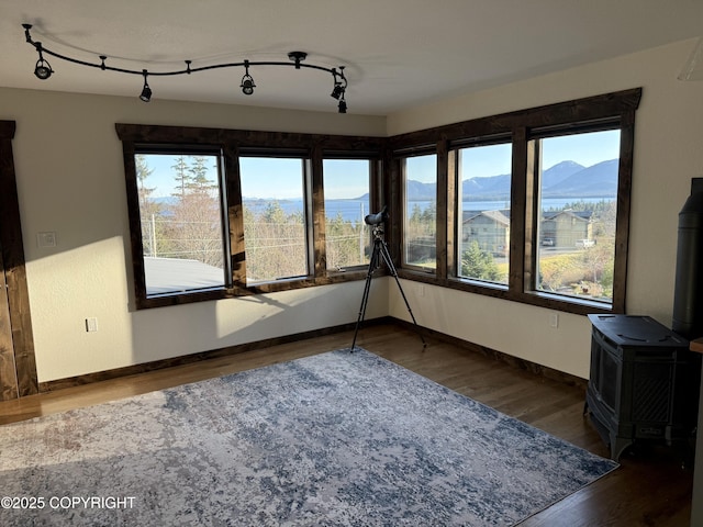 unfurnished sunroom with a mountain view and a wood stove