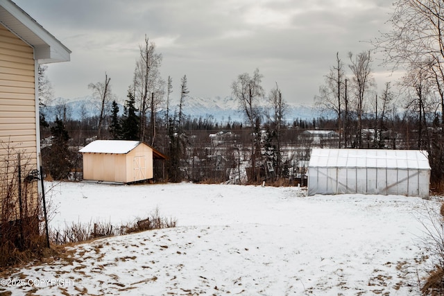 yard layered in snow featuring a storage shed