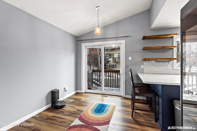 dining room featuring vaulted ceiling and dark hardwood / wood-style flooring