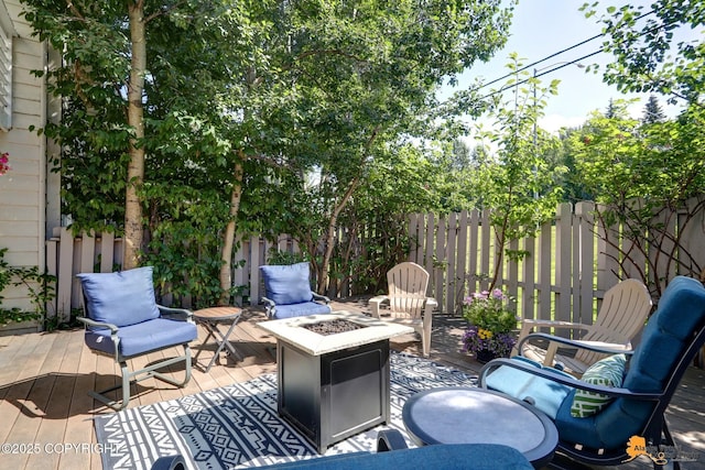 wooden terrace featuring an outdoor fire pit and fence