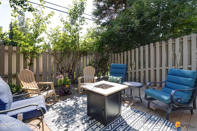 wooden terrace featuring a patio area, fence, and a fire pit