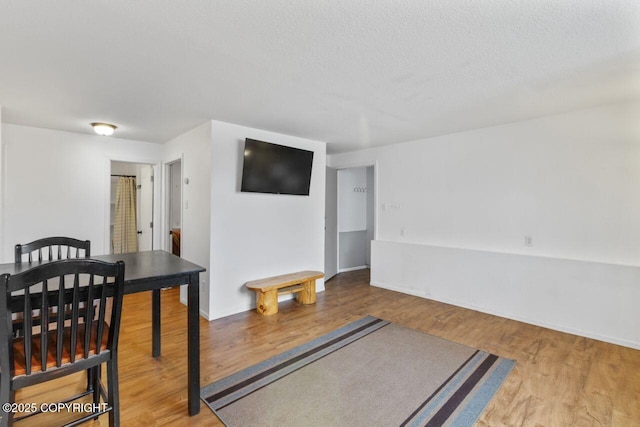 dining area featuring a textured ceiling and wood finished floors