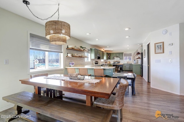 dining area with baseboards, a notable chandelier, wood finished floors, and recessed lighting