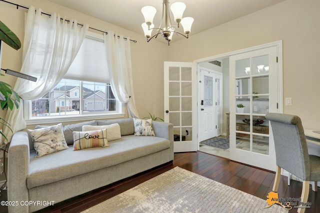 living area with dark wood-style floors and a notable chandelier