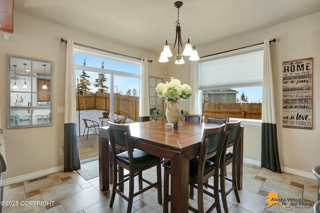 dining area featuring a chandelier, visible vents, and baseboards