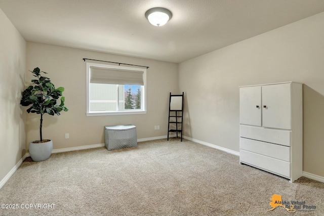 unfurnished room featuring carpet floors and baseboards