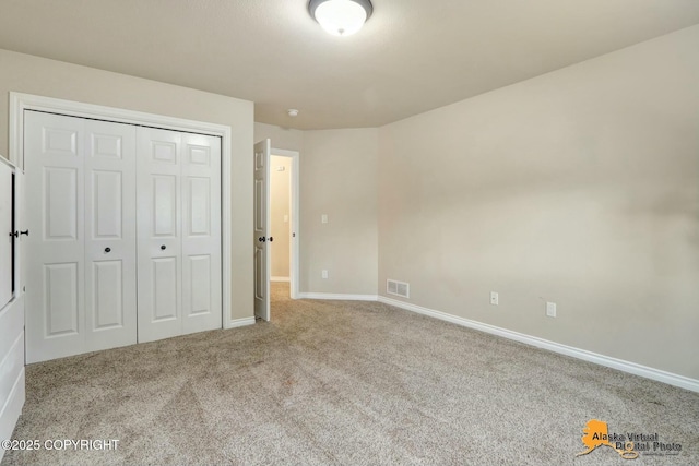 unfurnished bedroom featuring light carpet, baseboards, visible vents, and a closet