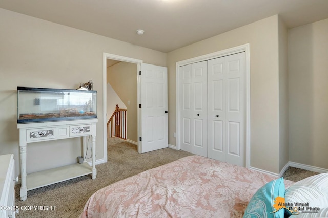 bedroom with carpet floors, baseboards, and a closet