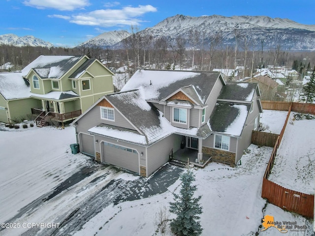 snowy aerial view with a residential view and a mountain view