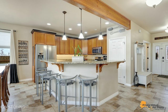 kitchen featuring a breakfast bar, hanging light fixtures, appliances with stainless steel finishes, brown cabinets, and beamed ceiling