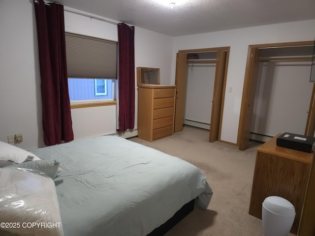 carpeted bedroom featuring a baseboard heating unit, a textured ceiling, and multiple closets