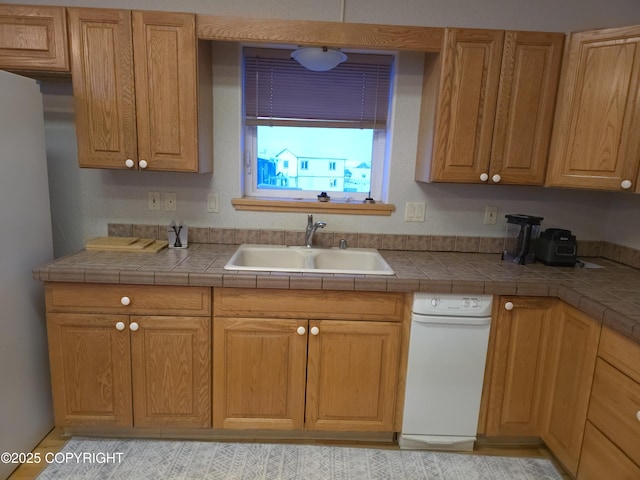 kitchen with sink, stainless steel fridge, and tile counters