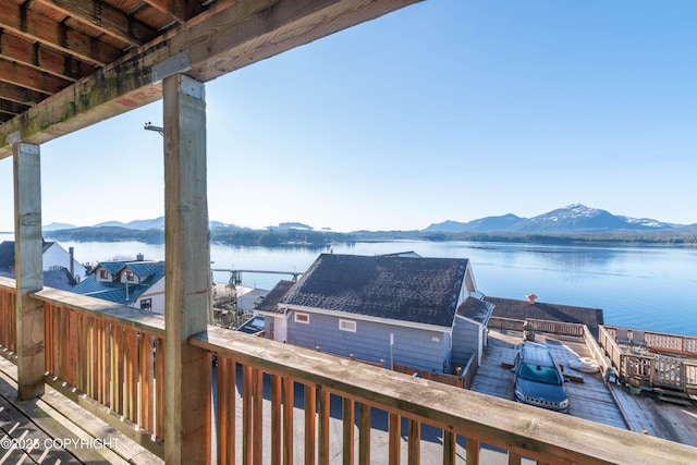 wooden deck with a water and mountain view