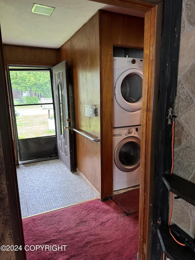 laundry area with carpet flooring and stacked washing maching and dryer