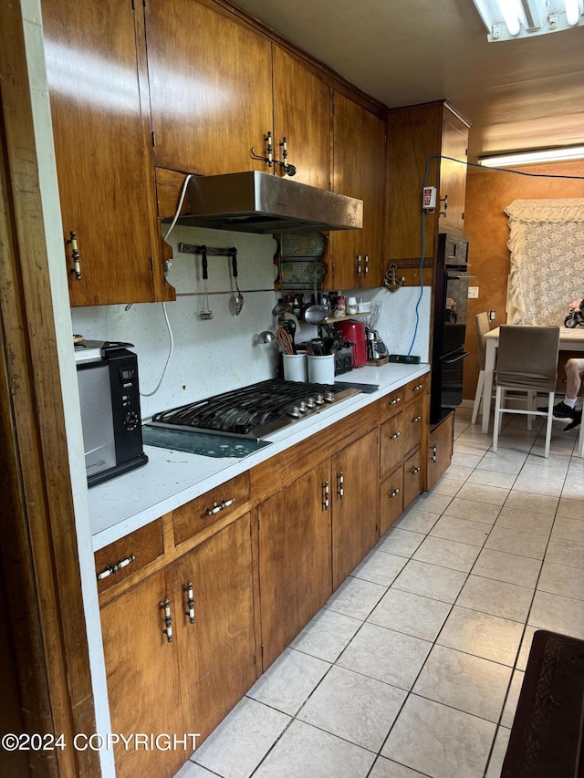 kitchen with black appliances and light tile patterned flooring