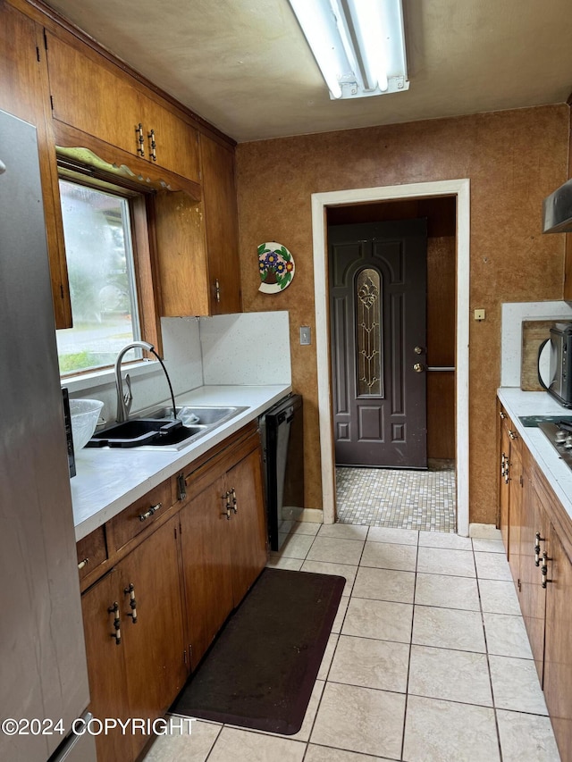 kitchen with light tile patterned floors, sink, and black appliances