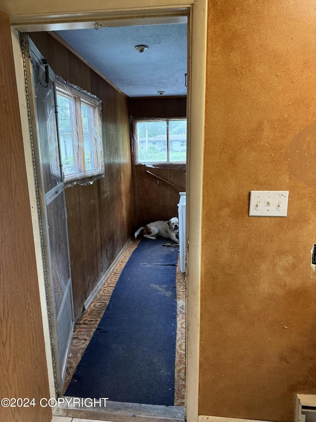 hallway featuring wood walls