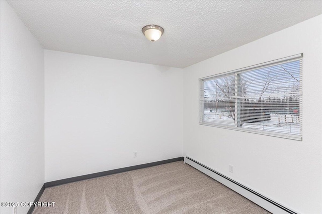 unfurnished room with carpet, a textured ceiling, a baseboard heating unit, and baseboards