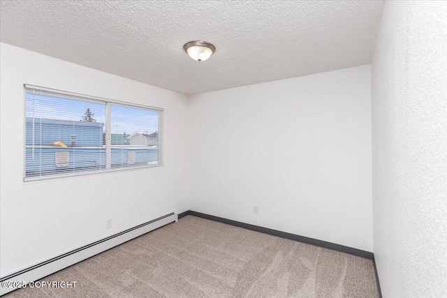 unfurnished room featuring a baseboard heating unit, a textured ceiling, carpet, and baseboards