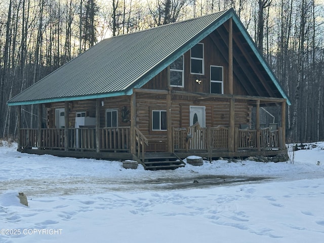 cabin with metal roof, a porch, and log exterior